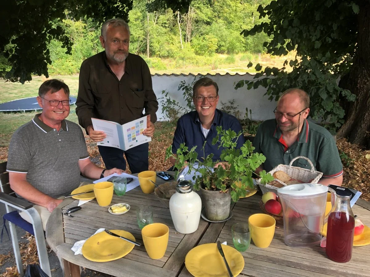 Fra venstre er Danske Arkegårdes formand, Jesper Eigen Møller, Stig Benzon, Kasper Roug samt professor Bernt Guldbrandtsen. Stig Benzon viser Interlaken-Deklarationen til Kasper Roug, og fortæller, at Danmark har tiltrådt internationale aftaler, om at vi skal bevare de gamle husdyrracer, som genetisk reserve. Foto: Stig Benzon