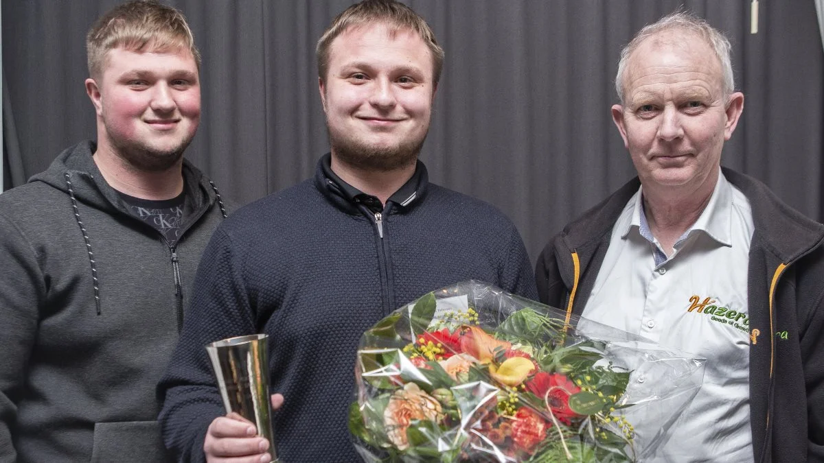 To sønner fra Hasmark Vestergård – Andreas Petersen (tv.) og Mathias Petersen – modtog Henrik Petersens pris som Årets Løgavler med pengepræmie, blomster og vandrepokal. Prisen blev overrakt af Niels Dalgaard, Hazera (th.) Foto: Annemarie Bisgaard, HortiAdvice