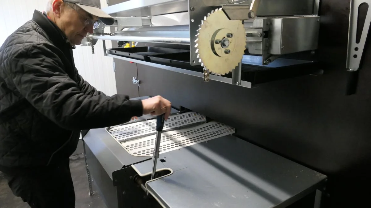 Æggene trækkes manuelt fra rederne ud til pakkebordet, hvor de lægges direkte i æggebakker. Det er også muligt at forsyne det mobile hønsehuse med eldrift af gødningsbånd og æggebånd. Foto: Bøje Østerlund