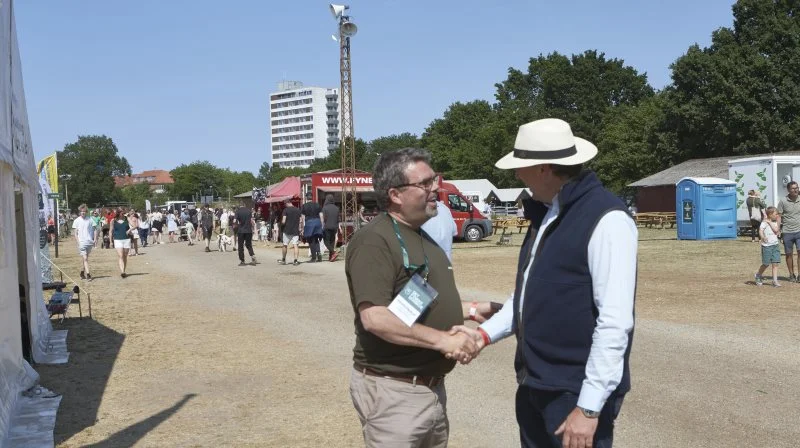 Dyrskueformand Torben Povlsen (tv.) havde kollegabesøg fra Roskilde Dyrskue, da næstformand Anders Mortensen var i Odense som hereforddommer. Bemærk den støvede dyrskueplads på grund af tørken og ikke mindst efter det tyske metalband Rammstein en uge forinden havde givet to koncerter med i alt 90.000 tilhørere på pladsen. Foto: Erik Hansen