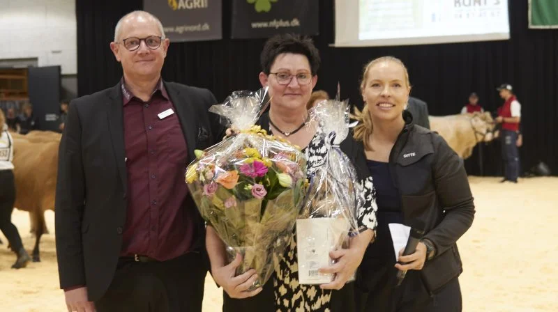 Det var en tydelig rørt Jonna Christoffersen, som blev hædret som en af Kimbrerskuets helt særlige ildsjæle. Hun modtog rosende ord, blomster og en gave af skuets formand Ditte Hammershøj (th) og Brian Otte, som er direktør i Messecenter Vesthimmerland. Foto: Tenna Bang
