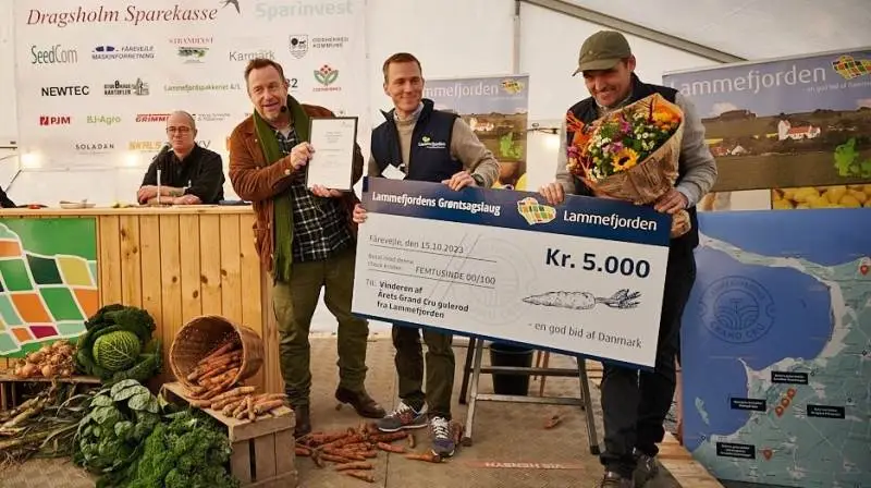 For tredje år i træk løb Arnakke Grøntsager med Grand Cru-prisen for bedste gulerod. Fra højre avlerne Christian Heslet-Jørgensen og Kristoffer Linderoth, konferencier Adam Price og dommer Sander Blohm. Foto: Peter Jarvad