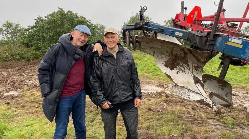 Henning Bruun-Schmidt (tv.) og Stig Jensen fra Initiativgruppen Houlkær foran den gigantiske dybdeplov på Klostermarkens naturområde en dag i oktober, hvor regnen strømmede ned og bevirkede en udsættelse af pløjningen. Foto: Hedeselskabet