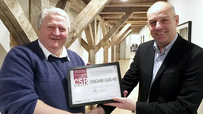 Her overrækker formanden for beskæftigelsesudvalget i Randers Kommune, Christian Boldsen (tv), CSR-prisen til Claus Berggren, administrerende direktør på Overgaard Gods A/S.