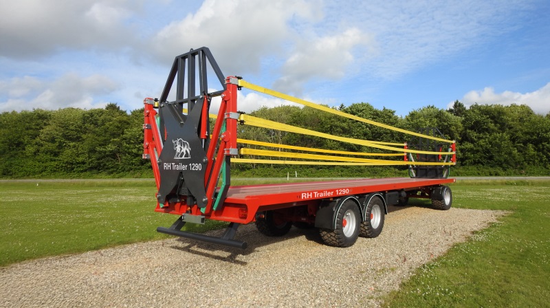 RH Trailer DK 1290 er den længste af de tre nye modeller i serien og har en ladflade på 12,9 meter. Her er den vist med påmonteret front- og bagrækværk samt hydraulisk lastsikring, der består af tre kraftige bånd i hver side. Systemet kører ned, når halmen læsses, og løftes op igen for at sikre læsset under kørsel. Pressefoto