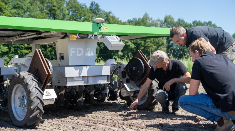 - FarmDroids evne til at håndtere nye, forskellige og større frø gør det muligt for os at drive en lille gård med forskellige afgrøder som løg, majs og rødbeder, siger landmand Nils Massmann (stående). Pressefotos