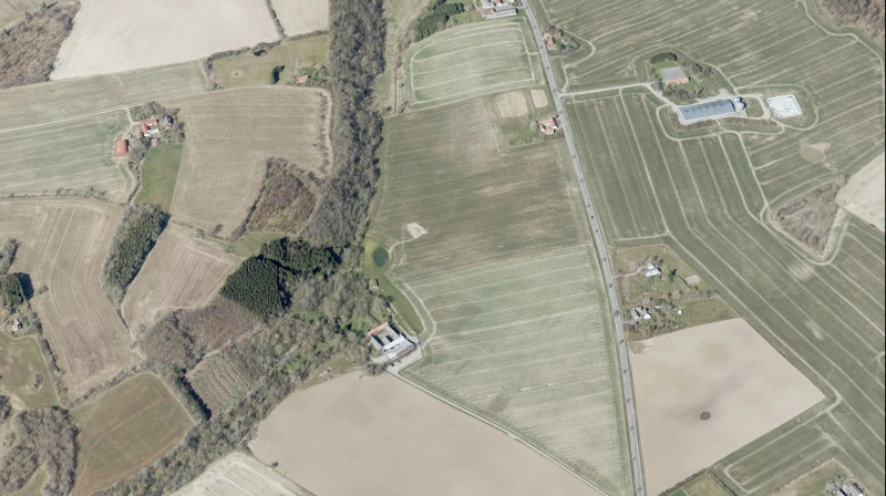 Lokalområdet omkring Pæregård nær Gudhjem på Bornholm er præget af landbrug og marker, som billedet her viser. Det er Pæregård i midten af billedet. Foto: Skråfoto/Styrelsen for Dataforsyning og Infrastruktur