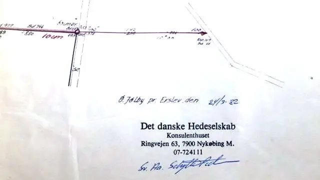 Drænsystemets udløb i vandløbet var i projektbeskrivelser altid lagt 10-20 cm over vandløbets bund for at sikre, at det drænede areal havde frit udløb ud i vandløbet. På illustrationen ses et eksempel: Udsnit af drænkort med Hedeselskabets stempel og angivelse af bundkote yderst til højre under den røde pil. Bundkoten er 64 og kote f. udløb er 100, så drænrøret udmunder 36 cm over vandløbsbund.