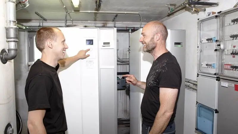 Svineproducent Frands Larsen (th), her sammen med installatør Kristian Galsgaard fra VP Klima, udnytter den naturlige varme fra gylle til at opvarme både stalde, et kontor og et stort værksted, samtidig med at han reducerer ammoniakudslippet. Pressefoto