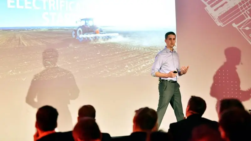 Simon Nielsen forklarede på Danfoss-mødet på Agritechnica, at omkring halvdelen af et moderne kvægbrugs arbejdsopgaver ville kunne løses af en el-traktor. Han vurderer, at traktorbranchen står foran en el-revolution. Foto: Danfoss