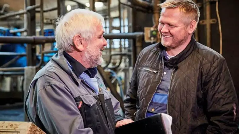 Mælkeproducent Jacob Bjerrum (th) har stor gavn af at have besøg af sin kvalitetsrådgiver Peter Uttrup fra Seges. Foto: Seges