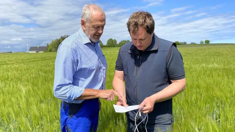 Gårdejer Erik R. Jensen og planteavlskonsulent Peter Hvid fra Djursland Landboforening, fortæller om hvad der sker aktuelt i marken på to digitale bedriftsbesøg på stedet. Foto: Djursland Landboforening.