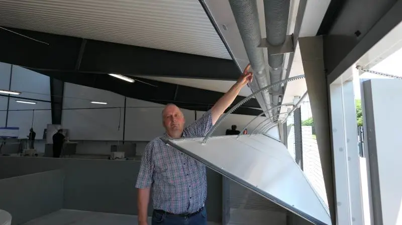 Erfarne Allan Kristensen fra Lystrup ved Aarhus glæder sig til at følge, hvor hurtigt de mange smågrise lærer sig at gå gennem vægten hver gang, de skal fodres. Foto: Bøje Østerlund