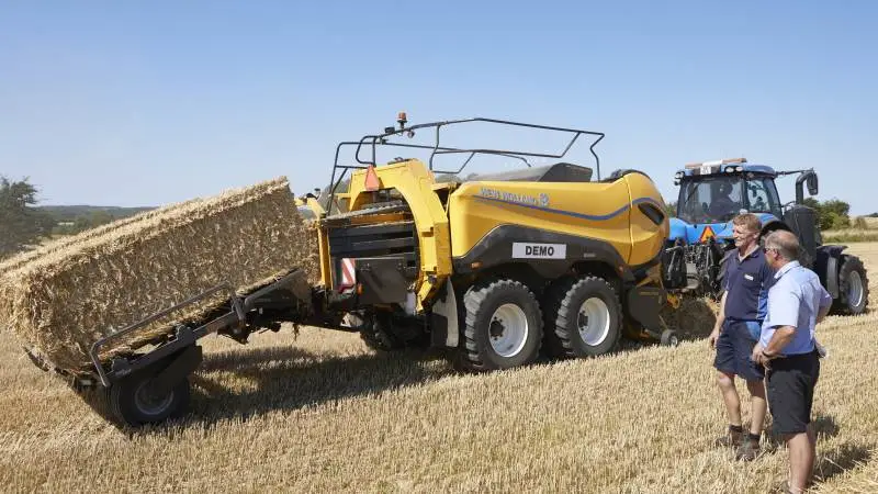 Salgskonsulent Niels Simonsen og montør Ole Hansen fra Kragmann A/S fremhæver den høje kapacitet, den rolige gang og de mange funktioner i den nye New Holland 1290 High Density storballepresser.