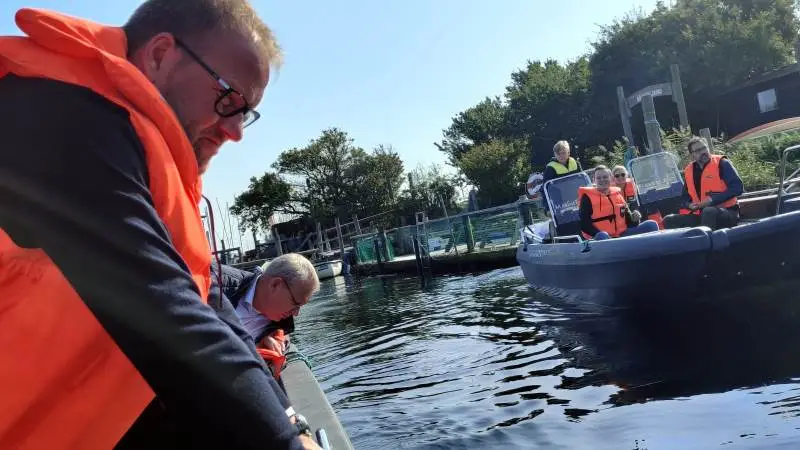 Dansk Folkepartis miljøordfører, René Christensen (forrest), og formanden for Landbrug & Fødevarer, Martin Merrild, så ved selvsyn masser af ålegræs i Karrebæk Fjord.