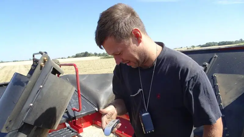 Johannes Karstofte tjekker her spandevægten af rajgræs og nyder hvor nemt og sikkert det er at komme op i korntanken på en Axial-Flow.