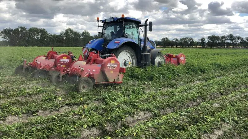 Grimme og Asa-Lift nye butterfly-aftopper med 2-rækkers Grimme-aftopper foran traktoren og Asa-Lift butterfly-enhed bag på traktoren. Pressefoto