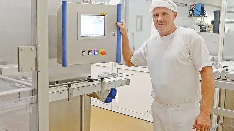 Mejeribestyrer Brian Madsen glæder sig over den nye maskine til pakning af flødeoste i bægre på 150 gram.